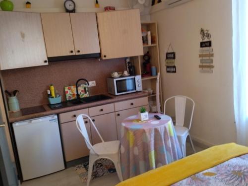 une petite cuisine avec une table et un micro-ondes dans l'établissement Studio mirabeau les halles 15m2 climatisation, à Narbonne