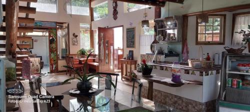 a room with a kitchen with a counter and some plants at Manacá Suítes Prumirim in Ubatuba