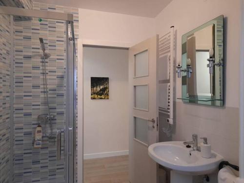 a bathroom with a sink and a shower with a mirror at Apartamento El Nido in La Guardia