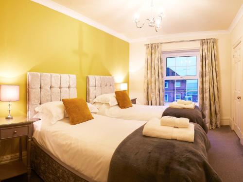twee bedden in een kamer met een raam bij The Hind House in Cowlam