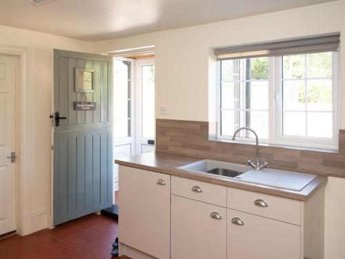 a kitchen with a sink and a window at The Hind House in Cowlam