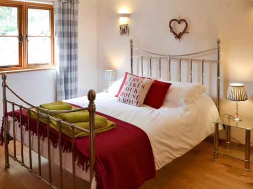 ChillendenにあるThe Stablesのベッドルーム1室(赤と白の枕が備わるベッド1台付)
