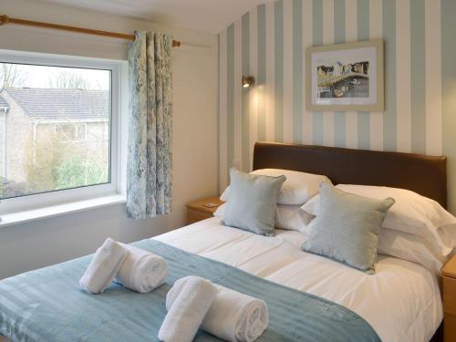 a bedroom with a large bed with towels on it at Newquay Holiday Villa in Saint Columb Major