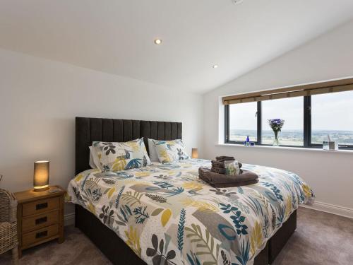 a bedroom with a bed with a large window at The Barn At Toft Hill Hall in High Etherley