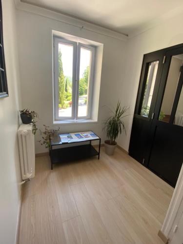 un salon avec une table et une fenêtre dans l'établissement Chambre d'hôtes Zephyr Libeccio Le Moulin de Prédelles, à Reillanne