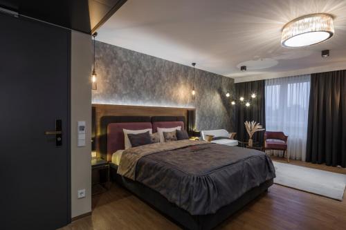 a bedroom with a large bed and a table and chairs at Design Hotel Winterrot in Karlsruhe