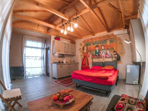 a bedroom with a red bed in a wooden room at Batumi Wonderland Guest House in Batumi
