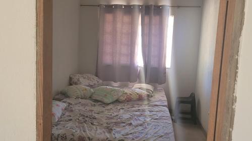 a small bed in a room with a window at Serrado Porteirinha Pedacinho do céu in Porteirinha