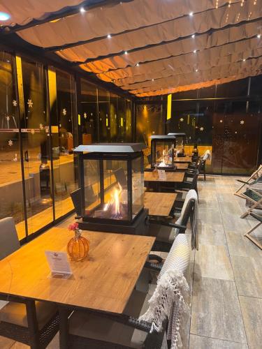 a row of tables with a fireplace in a restaurant at Design Hotel Winterrot in Karlsruhe