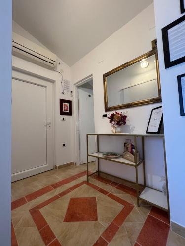 a hallway with a white door and a mirror at Apartmani M&L in Medulin