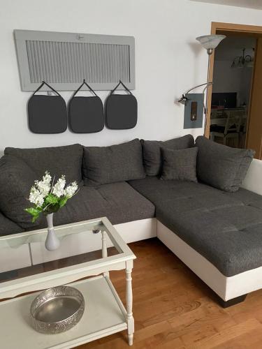 a living room with a gray couch and a table at Casa Bianca Souterrain in Kappel-Grafenhausen