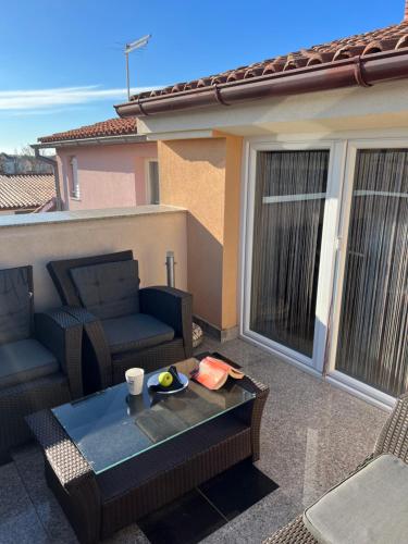 a patio with a couch and a table on a balcony at Apartmani M&L in Medulin