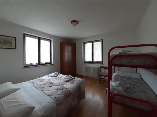 レーヴィコ・テルメにあるAppartamento Lagoのベッドルーム1室(ベッド2台、二段ベッド1組付)