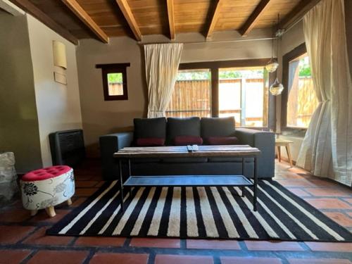 sala de estar con sofá y alfombra en Casita de Villegas en San Martín de los Andes