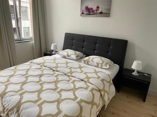 een slaapkamer met een groot bed met een zwart hoofdeinde bij Modern Apartment Third Floor in Brussel