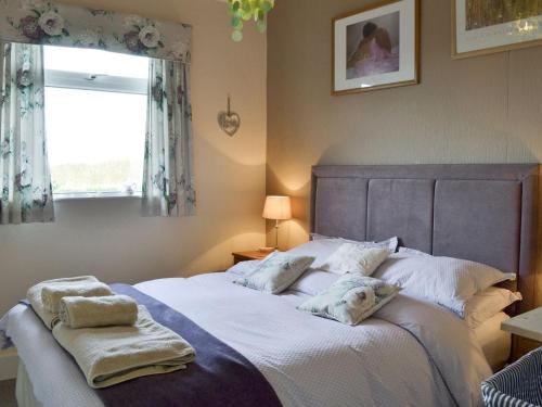 a bedroom with a large bed with towels on it at Searchlight Cottage in Fraisthorpe