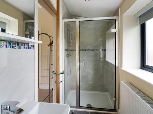 um chuveiro com uma porta de vidro na casa de banho em Woodland View - Ukc3893 em Coton in the Elms