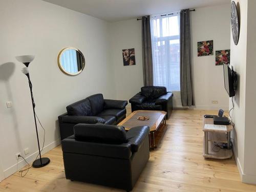 sala de estar con mesa y muebles de cuero negro en Modern Apartment Third Floor, en Bruselas