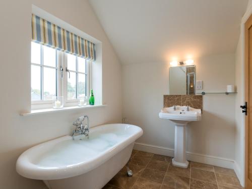 a bathroom with a tub and a sink at White Lodge Cottage in Carlton Miniott