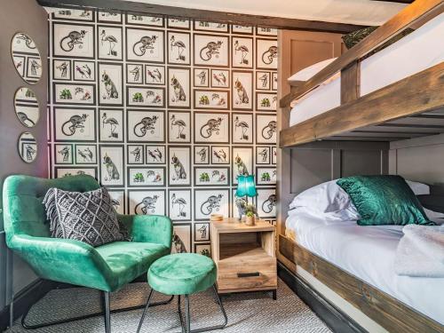 a bedroom with a bunk bed and a green chair at The Twisted Toad in Guisborough