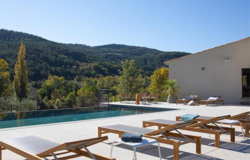 uma villa com uma piscina com montanhas ao fundo em La Grange de Fer I Classée 5 étoiles em Saint-Ferréol-Trente-Pas