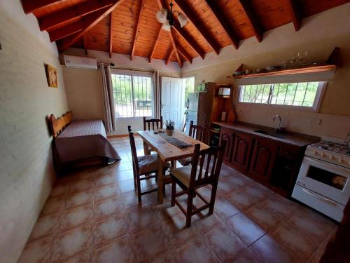 a kitchen with a table and chairs in a room at Cabañas la Delfina in Potrero de los Funes