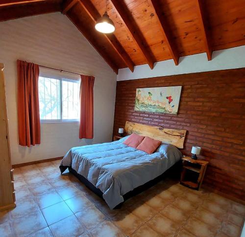 a bedroom with a bed and a brick wall at Cabañas la Delfina in Potrero de los Funes