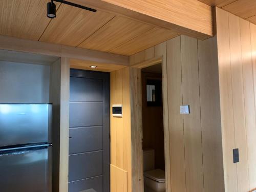 a kitchen with a door and a refrigerator in a room at HUEPIL, Monoambiente Centrico in San Martín de los Andes