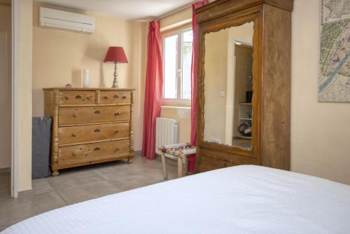 a bedroom with a bed and a dresser and a mirror at Villa Maredda in La Ciotat