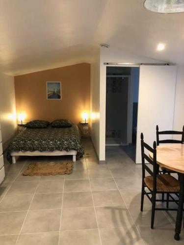 une chambre avec un lit, une table et des chaises dans l'établissement Studio quartier calme, à La Roche-sur-Yon