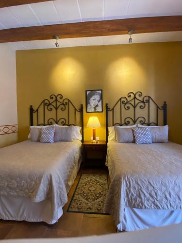 a bedroom with two beds and a lamp in it at Hotel Casa Mar&iacute;a F&eacute;lix in &Aacute;lamos
