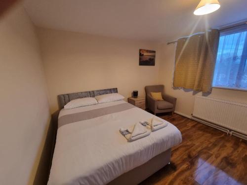 a bedroom with a bed and a chair and a window at Star Homes in London