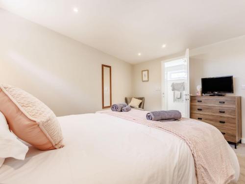 a bedroom with a large white bed and a tv at Kingsleys Lodge in Barnstaple