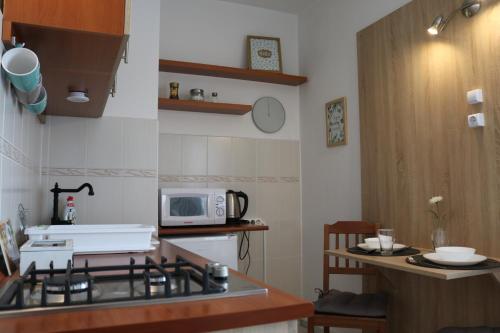 a kitchen with a stove and a microwave at Liliom Apartman Pécs in Pécs