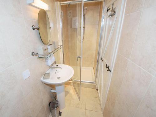een badkamer met een wastafel en een douche bij Cobble Cottage30c - Ukc2846 in Blakeney