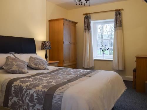 a bedroom with a large bed and a window at Maesbangor Farmhouse in Capel Bangor