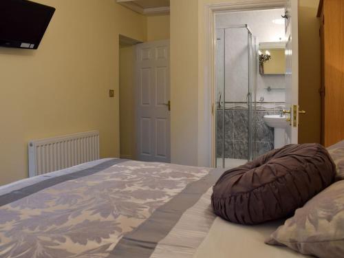 a bedroom with a large bed with a pillow on it at Maesbangor Farmhouse in Capel Bangor