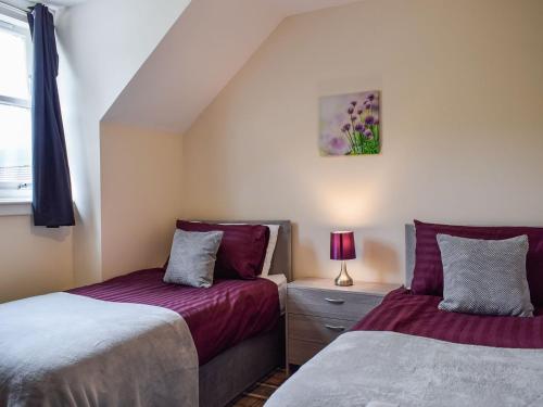 a bedroom with two beds and a window at Beechwood in Arrochar