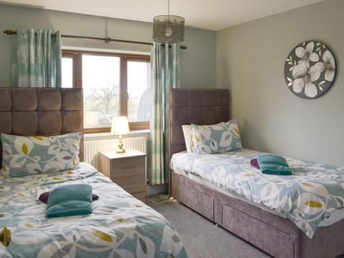 1 dormitorio con 2 camas y ventana en Carp Cottage - Ukc1907 en Doddington