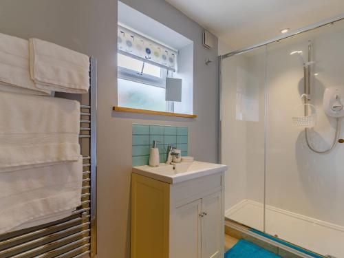 a bathroom with a sink and a shower at Acorn Cottage in Knutsford
