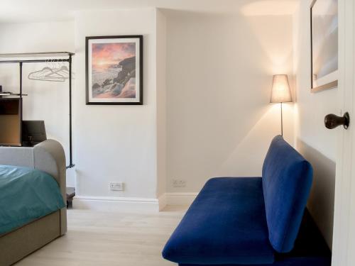 um quarto com uma cadeira azul e uma cama em Morton Loft em Hathersage