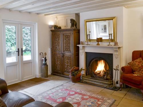 a living room with a fireplace and a mirror at Walnut Tree House in Terrington Saint John