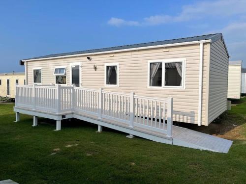 een stacaravan met een veranda en een terras bij Lexi Lodge @ Littlesea Holiday Park, Weymouth in Wyke Regis