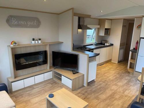 a living room with a kitchen and a living room with at Lexi Lodge @ Littlesea Holiday Park, Weymouth in Wyke Regis