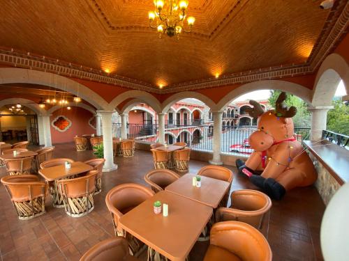 a restaurant with a large teddy bear sitting next to tables at Hotel Real de los Alamos in Álamos