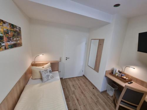 a small room with a bed and a desk at Gästehaus Grunewald Bed & Breakfast in Heiden