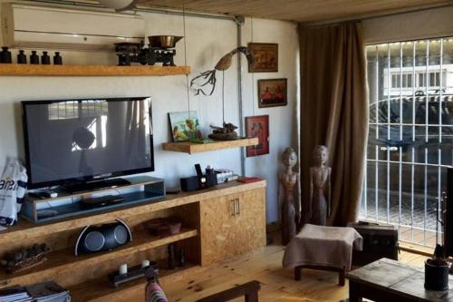 a living room with a flat screen tv on a entertainment center at Piedra De Agua Chacra, casa, piscina, bosque, río. in Minas