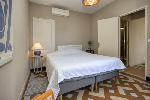 ラ・シオタにあるVilla Mareddaのベッドルーム(白いベッド1台、ランプ付きテーブル付)