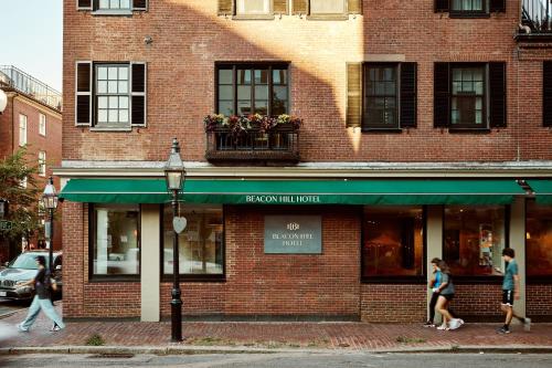 a brick building with people walking in front of a store at Beacon Hill Hotel in Boston