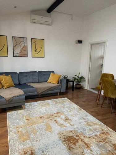 a living room with a blue couch and a rug at Apartament la casa in Timişoara
